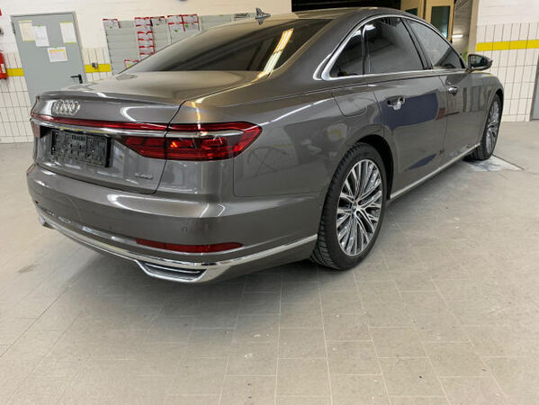 Grauer Audi A8 von hinten in Werkstatt, Limousine mit LED-Rückleuchten