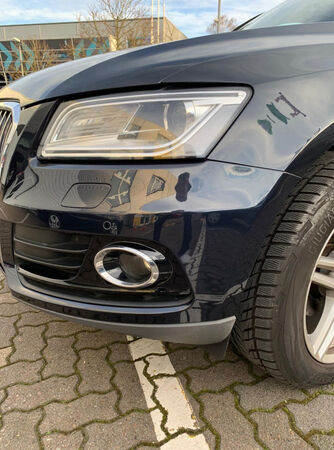 Nahaufnahme der Frontstoßstange am Auto mit Kratzern und Beule am Kotflügel