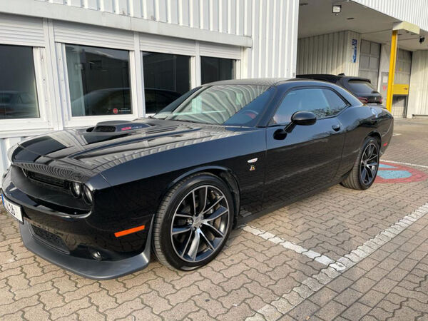 Schwarzes Dodge Challenger Muscle Car vor Werkstatt, Seitenansicht außen